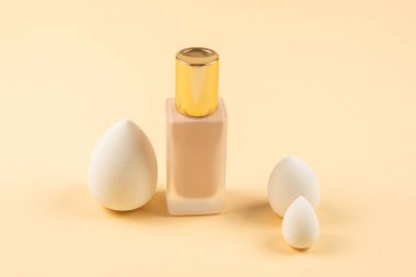 Bej arka planda küçük, orta ve büyük beyaz güzellik karıştırıcısı ve makyaj vakfı. Üst görünüm. 