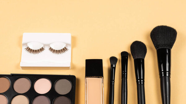 Professional makeup products with cosmetic beauty products, eye shadows, eye lashes, beauty blender, foundation,  brushes and tools.