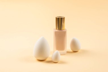 Bej arka planda küçük, orta ve büyük beyaz güzellik karıştırıcısı ve makyaj vakfı. Üst görünüm. 