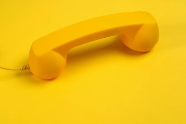 Sarı arka planda sarı bir cep telefonu. Boşluğu kopyala.