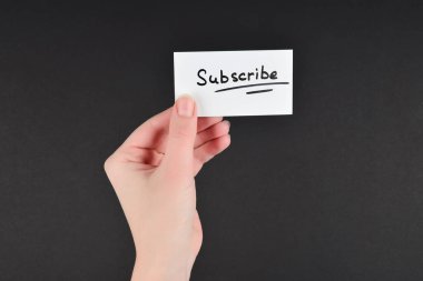 Siyah arkaplan üzerinde kadın eli olan bir karta abone ol.