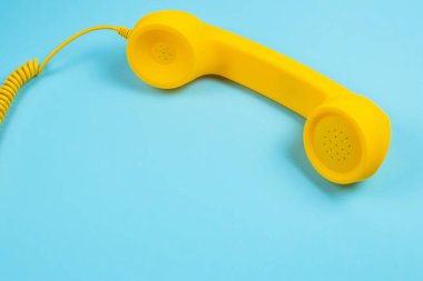 Mavi arka planda sarı bir cep telefonu. Boşluğu kopyala.