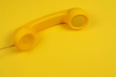 Sarı arka planda sarı bir cep telefonu. Boşluğu kopyala.