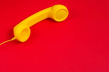 Kırmızı arka planda sarı cep telefonu. Boşluğu kopyala.