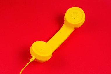 Kırmızı arka planda sarı cep telefonu. Boşluğu kopyala.