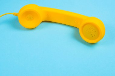 Mavi arka planda sarı bir cep telefonu. Boşluğu kopyala.
