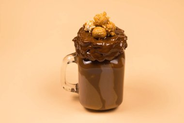 Çikolatalı milkshake, çırpılmış krema, kurabiye, waffle, cam mason kavanozunda servis edilir. 