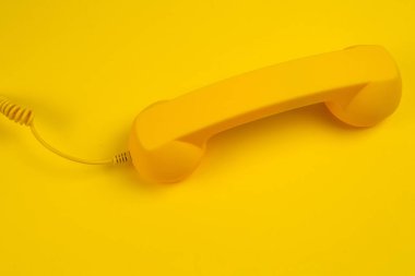 Sarı arka planda sarı bir cep telefonu. Boşluğu kopyala.