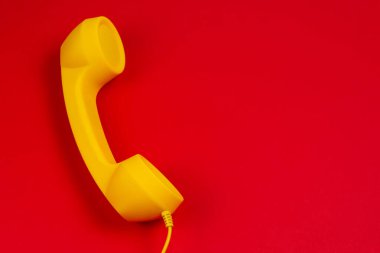 Kırmızı arka planda sarı cep telefonu. Boşluğu kopyala.