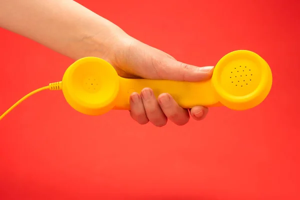 Auricular Amarillo Sobre Fondo Rojo Mano Mujer Copiar Espacio —  Fotos de Stock