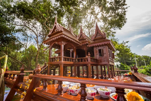 Beautiful Thai style spirit house or house of the guardian spirit is made of wood and sculptured wood. Thai houses ancient style pattern. Foreshorten.