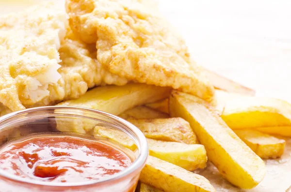 Traditional British street food fish and chips with ketchup sauc