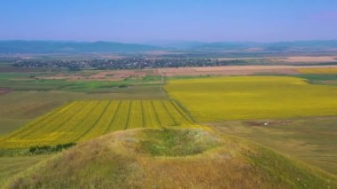 Yazın kırsal alanda uçan drone, yeşil tepe ve renkli kültür alanları