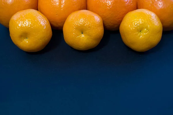 Las Mandarinas Brillantes Yacen Armoniosamente Sobre Fondo Azul Oscuro — Foto de Stock
