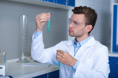 Keşfetmek sürükleyici. Sevimli yakışıklı perspektif discoverer laboratuvarda araştırma ve şişeleri baktılar arıyorsunuz test gözlük ile çalışma.