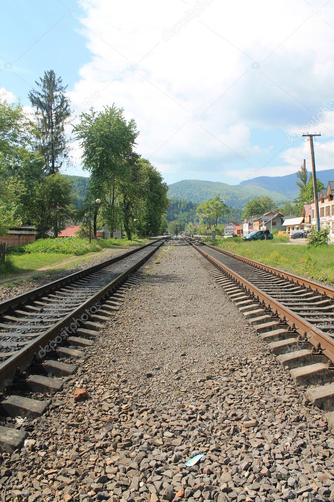 railroad tracks leading to distant foothills of Carpathian Mount