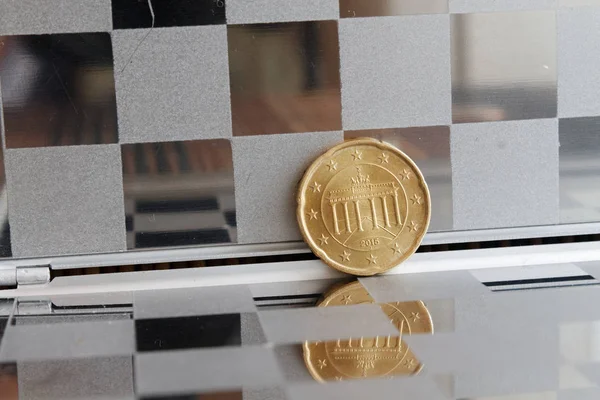 Moeda de euro com uma denominação de vinte cêntimos de euro no espelho refletem carteira, fundo chequered - verso — Fotografia de Stock