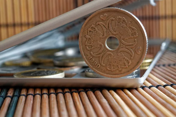 Куча датских монет номиналом в пять крон (корона) в зеркале отражают бумажник лежит на деревянном бамбуковом фоне - задней стороне — стоковое фото