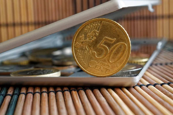 Σωρός από κέρματα ονομαστικής αξίας ευρώ 50 σεντς σε καθρέφτη αντανακλούν πορτοφόλι ψέματα σε ξύλινα μπαμπού πίνακα φόντο — Φωτογραφία Αρχείου