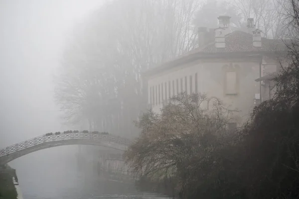 Oude boogbrug stenen brug in mistig weer, haze winter in Italië — Stockfoto