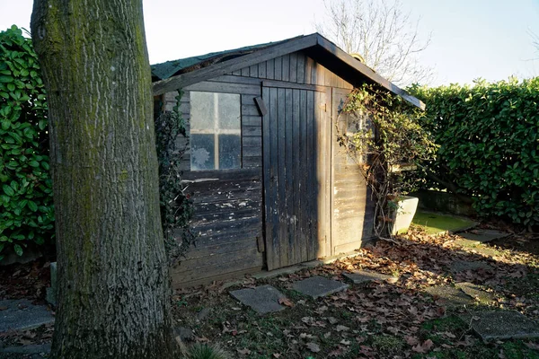 Old desolate barn with dirty vintage window, cute small house on back yard — Stock Photo, Image