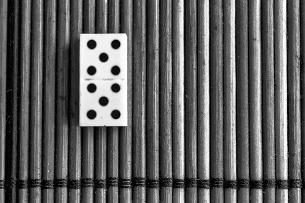 Monocromático Domino peça sobre o fundo de mesa de madeira marrom de bambu. Jogo de dominó - cinco - 5 pontos — Fotografia de Stock
