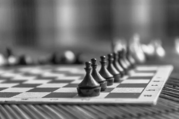Tek renkli ahşap satranç tahtası ve çelik satranç taşları, gemide izole