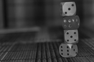 Üç beyaz plastik dices ve kahverengi ahşap tahta arka plan üzerinde kırmızı bir zar tek renkli yığını. Altı iki küp siyah noktalar ile. Numara 3, 4, 5, 6.