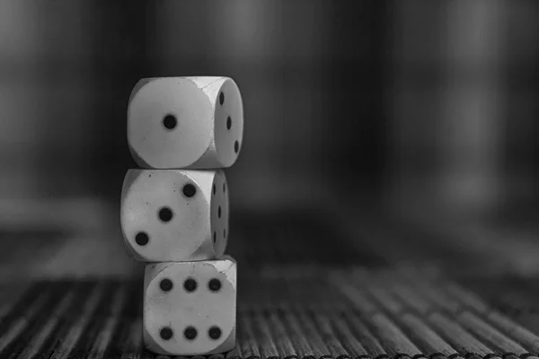 Monochrome Stack of three white plastic dices on brown wooden board background. Six sides cube with black dots. Number 1, 3, 6. — Stock Photo, Image