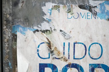 Teneke üzerinde oy dokulu duvar sonra yırtık poster. Yırtık gazete