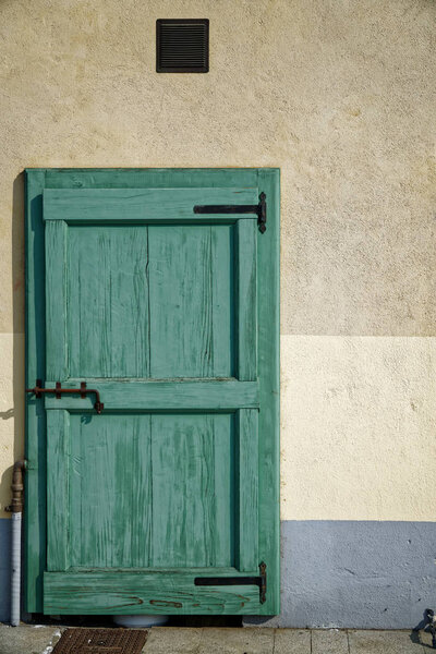 Ancient door in green color, cracked wooden entrance, sample for post card.