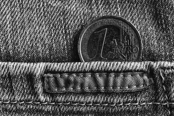 Euro koin dengan denominasi 1 euro di saku celana jeans denim tua usang, tembakan monokrom — Stok Foto