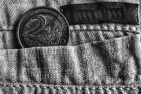 Euro coin with a denomination of two euro in the pocket of linen pants with black stripe, monochrome shot — Stock Photo, Image