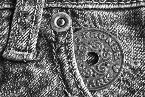Denmark coin denomination is 5 krone (crown) in the pocket of worn light denim jeans, monochrome shot