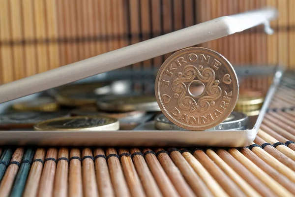 Stapel von Mark-Münzen mit einer Stückelung von 1 Krone (Krone) im Spiegel spiegeln Brieftasche liegt auf hölzernem Bambus-Tischhintergrund — Stockfoto