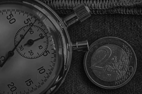 欧元硬币与一个面值的两个欧元和秒表在破旧的牛仔布与红色条纹背景-业务背景 — 图库照片