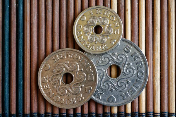 Drie Denemarken munten denominatie is 5, twee- en 1 kroon (kroon) liggen op houten bamboe tafel, goed voor de achtergrond of briefkaart — Stockfoto