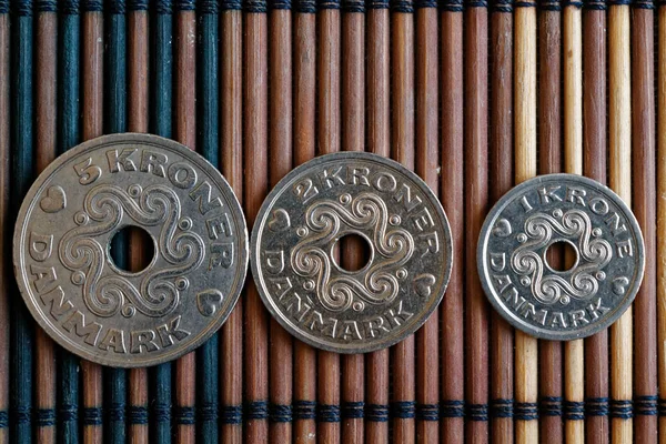 Τρεις κέρματα ονομαστικής αξίας Δανία είναι 5, 2 και 1 κορόνα (crown) βρίσκονται στο τραπέζι ξύλινο μπαμπού, καλό για φόντο ή καρτ-ποστάλ — Φωτογραφία Αρχείου