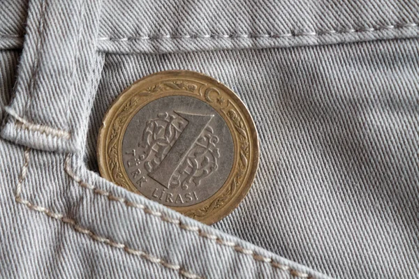 Turkish coin with a denomination of 1 lira in the pocket of old beige denim jeans