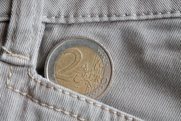 Moneda en euros con una denominación de 2 euros en el bolsillo de vaqueros blancos —  Fotos de Stock