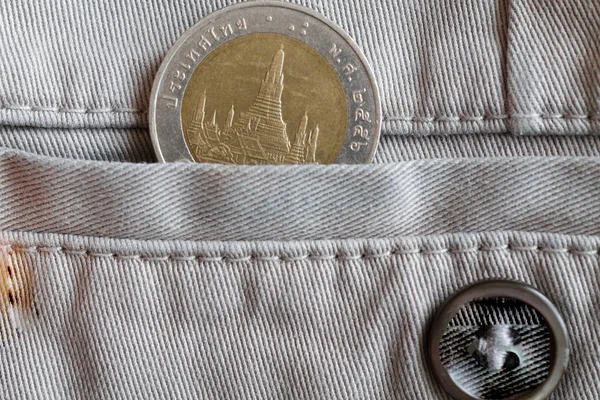 Tajski moneta z nominału 10 bahtów w kieszeni beżowych jeansów z guzikiem — Zdjęcie stockowe