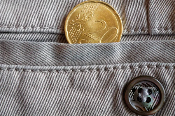 Moneta in euro con un taglio di venti centesimi di euro nella tasca di jeans denim beige con bottone — Foto Stock