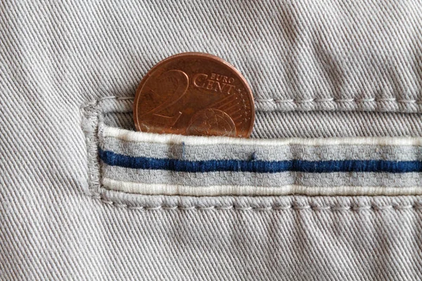 Pièce en euros avec une valeur unitaire de 2 centimes d'euro dans la poche de jeans en denim blanc à rayures bleues — Photo