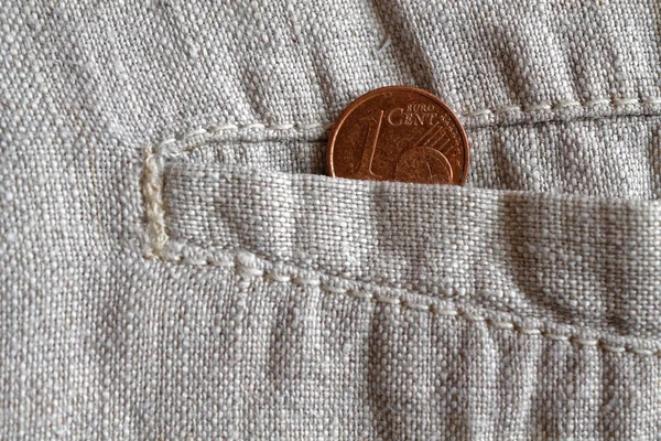 Euromunten met een nominale waarde van 1 euro cent in de zak van versleten linnen broek — Stockfoto