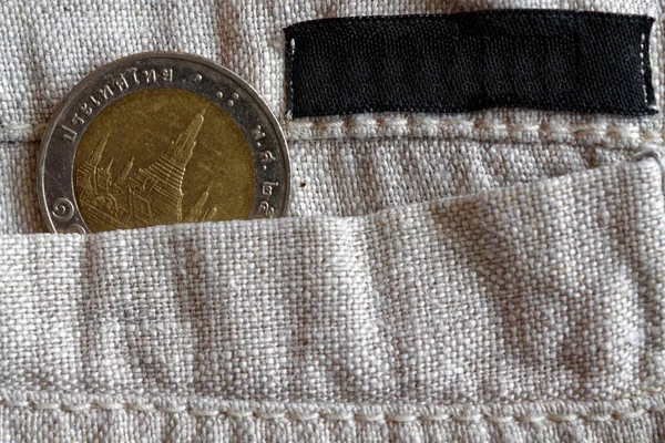 Moneta tailandese con un taglio di 10 baht nella tasca dei pantaloni di lino con striscia nera per l'etichetta — Foto Stock