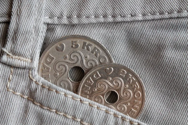 Il taglio delle monete danesi è di cinque e due corone (corona) nella tasca dei vecchi jeans in denim beige — Foto Stock