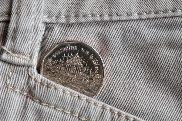 오래 된 베이 지 데님 청바지의 주머니에 5 바트의 명칭으로 태국 동전 — 스톡 사진