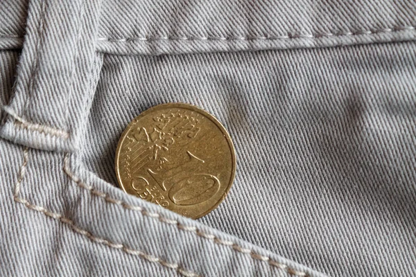 Euro coin with a denomination of 10 euro cents in the pocket of white denim jeans