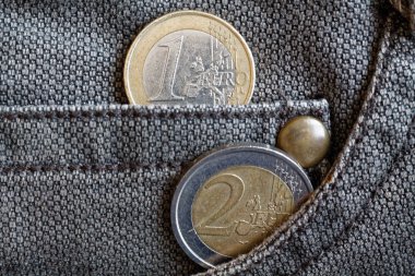 1 ve 2 euro yıpranmış kahverengi denim kot pantolon cebinde bir mezhebi ile Euro coins