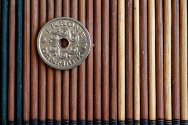 Danimarka jeton mezhebi 1 Kronu (taç) ahşap bambu masada iyi arka plan veya kartpostal için yalandır